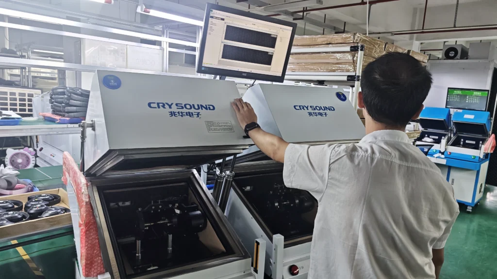 Automated acoustic testing station with dual sound-isolated test chambers for headphones.