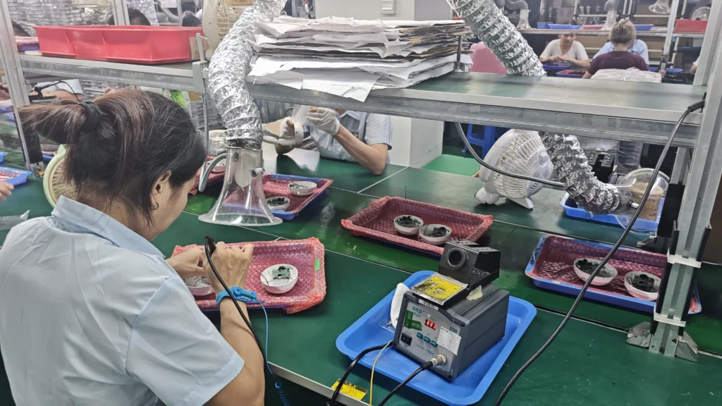 Precision hand soldering workstation for earphone component assembly with fume extraction.